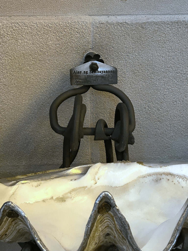 At the Sagrada Família, six holy water fonts made from Philippine giant clam shells (Tridacna gigas, taklobo) are easily overlooked. Donated by the Philippines in 2010 in line with Antoni Gaudí’s original design, each bears a bilingual plaque: “Alay ng Sambayanang Filipino / Ofrenda del pueblo Filipino.”